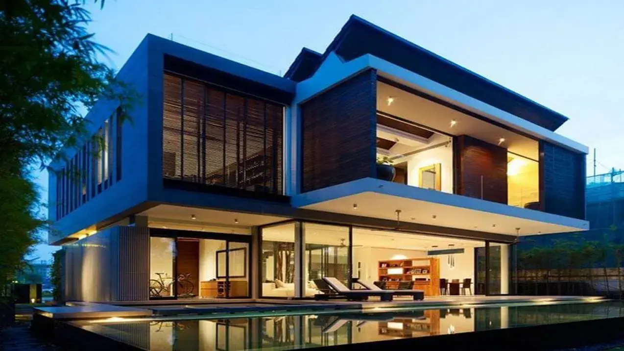 imóvel de alto padrão com arquitetura moderna em vidro e madeira, piscina de borda infinita e vegetação exuberante.