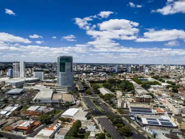 Vista aérea da paisagem urbana do bairro Santa Mônica em Uberlândia, Minas Gerais, com prédios, árvores e dois arranha-céus.
