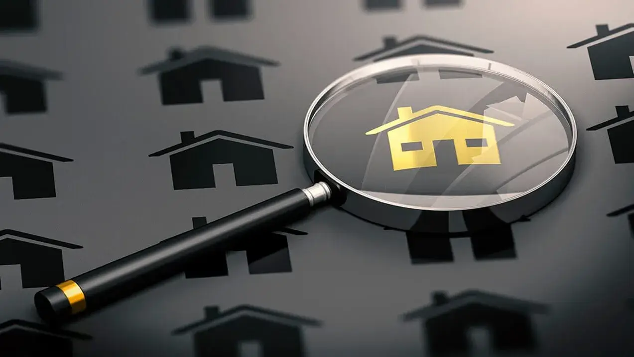 Lupa com ícone de casa sobre imóveis, ilustrando o processo de como captar imóveis com foco e atenção nos detalhes.