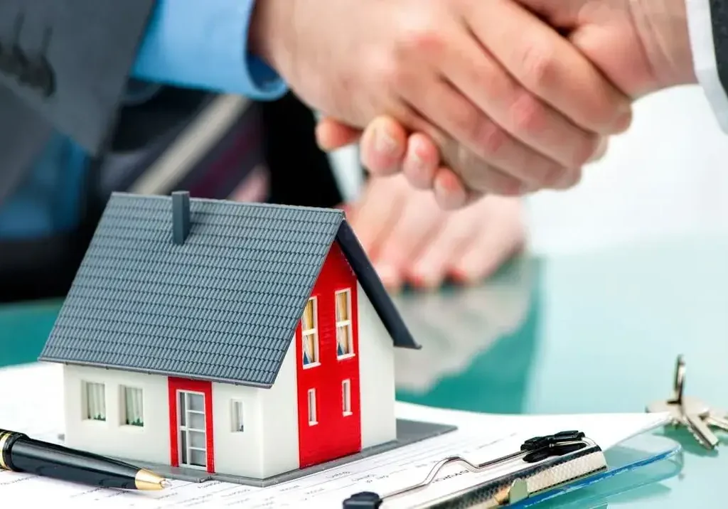 Aperto de mãos sobre casa miniatura simboliza o sucesso nas principais etapas da captação de imóveis.